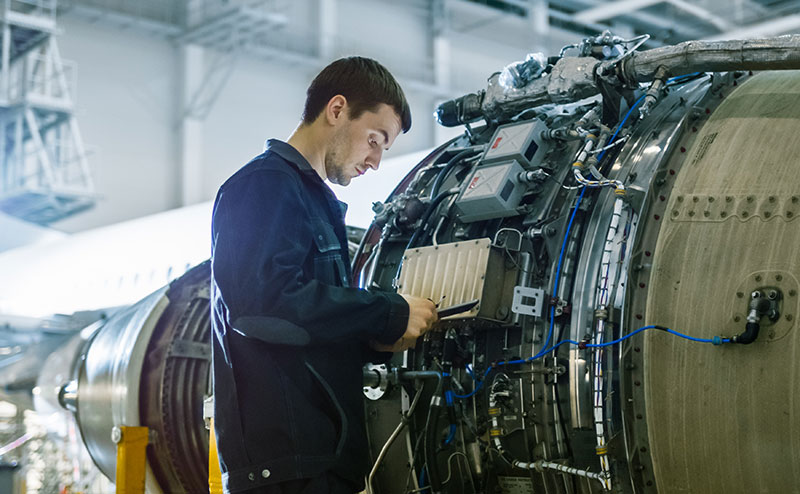 Engineer working on commercial jet engine