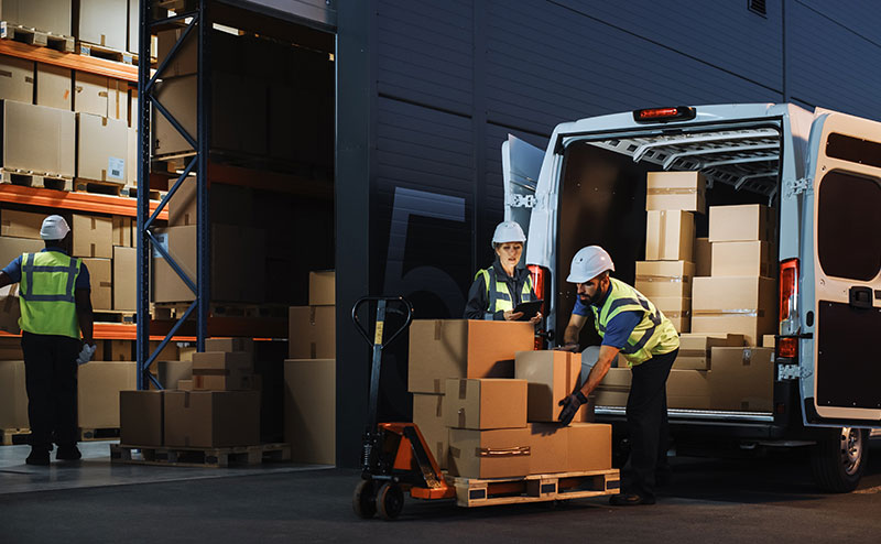 Logistics staff loading a van